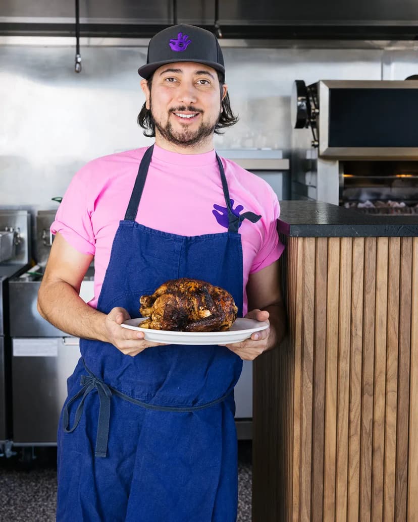 cook holding a roast chicken